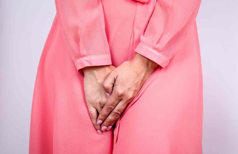 A incontinência urinária é um problema comum entre idosos e pode ter um grande impacto na qualidade de vida. A foto de uma senhora com as duas mãos sobre a pelve.