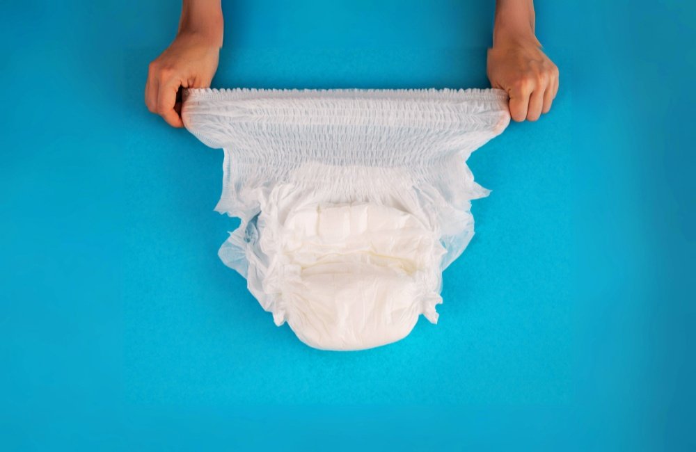 Tena pants confort. Foto de uma roupa intima descartavel esticanda sendo demonstrada por uma pessoa.